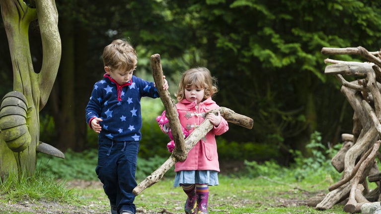 Two young children den building at Sheringham Park